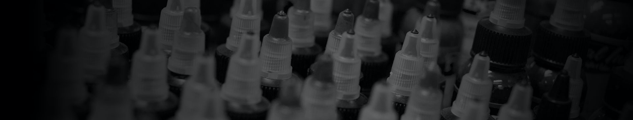 Plastic bottles with nozzle caps, closely arranged.