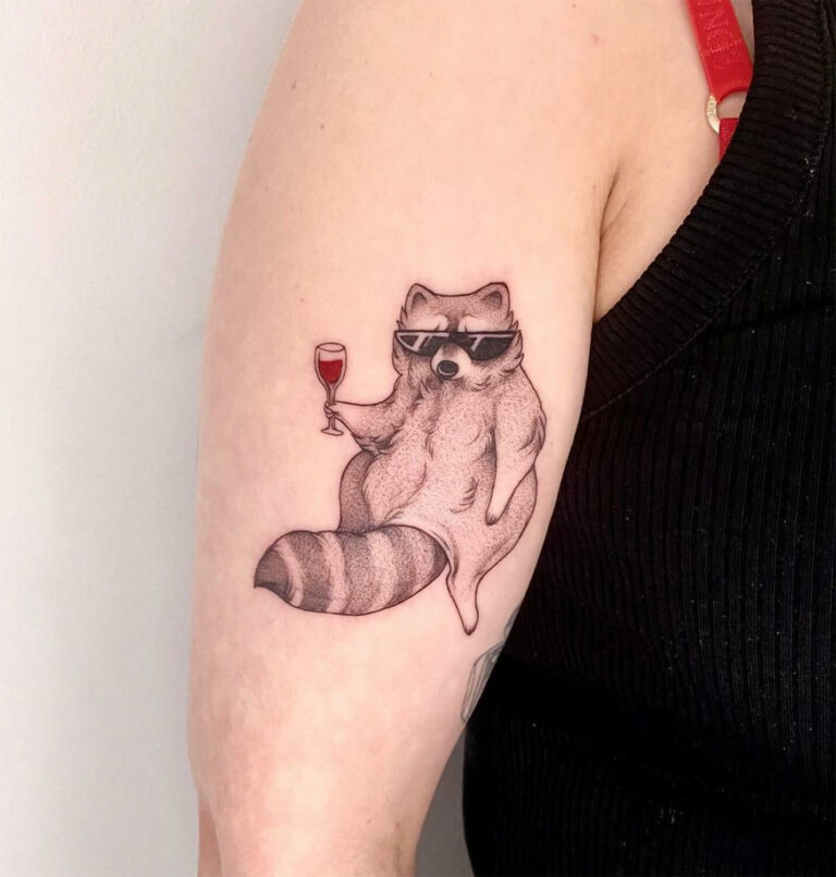 Black and grey tattoo of a racoon wearing sunglasses holding a wine glass