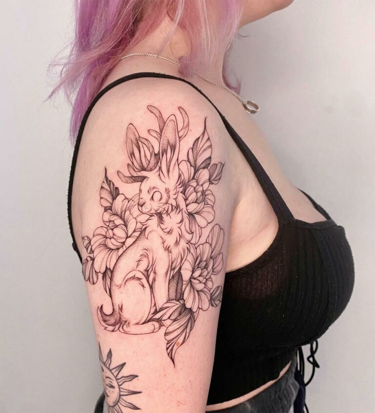 Black and grey illustrative jackalope and floral tattoo
