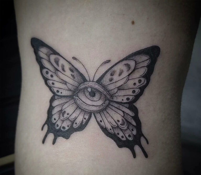 Black and grey tattoo of an eye with butterfly wings