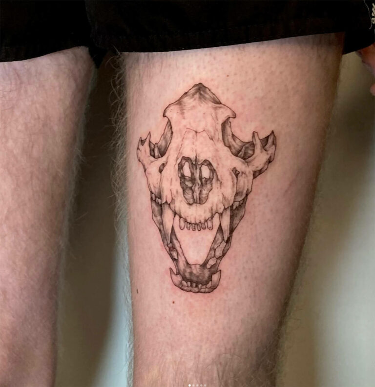 Tattoo of a detailed animal skull inked on a person's upper thigh.