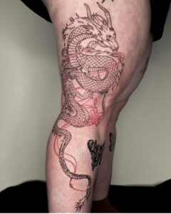 Linework dragon tattoo from upper thigh to below the knee