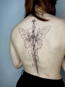 Tattoo of sword with fairy wings spanning the length of the spine