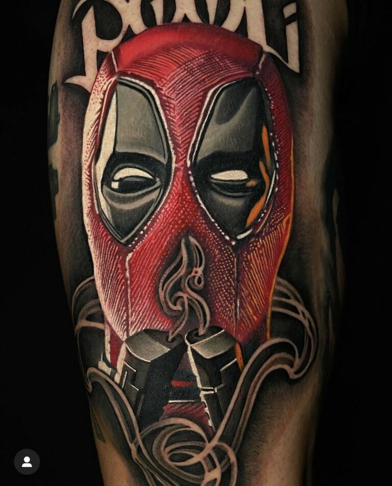 A tattoo of a masked character in red and black with swirling designs and partial lettering.