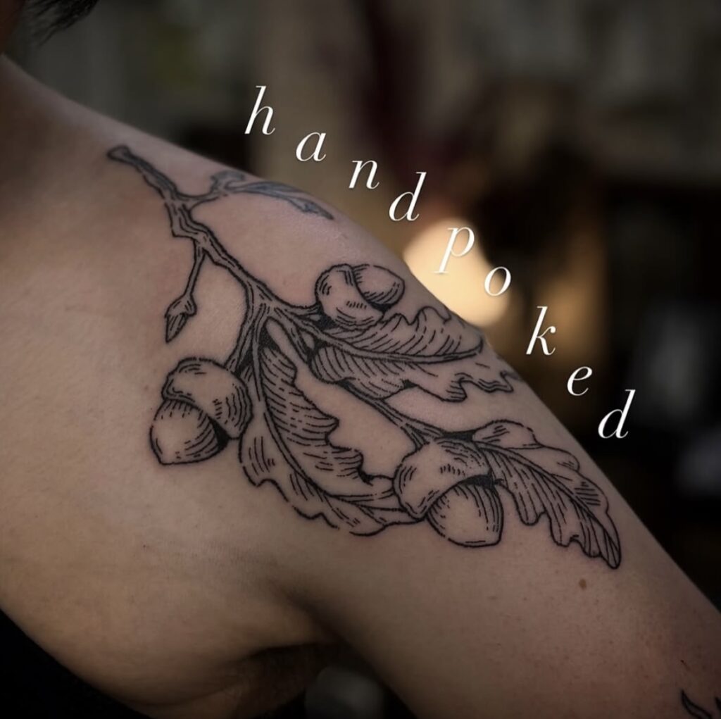 Hand-poked tattoo on shoulder, featuring an oak branch with leaves and acorns.