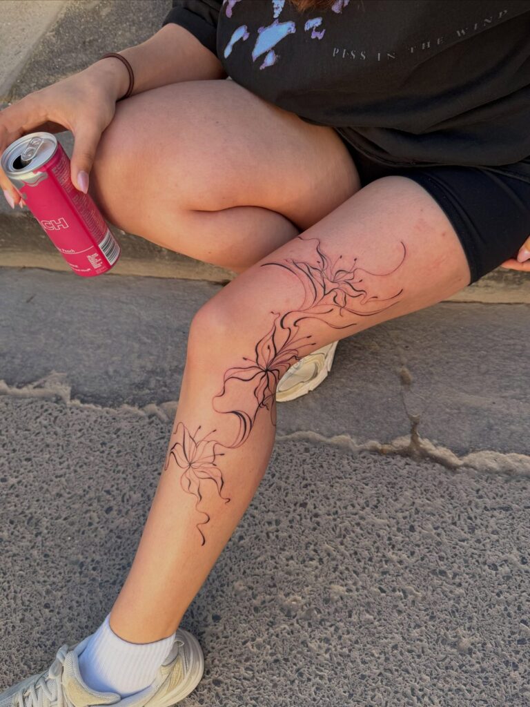 Abstract lily tattoos flowing around the knee and lower leg by Chanelle Pititto