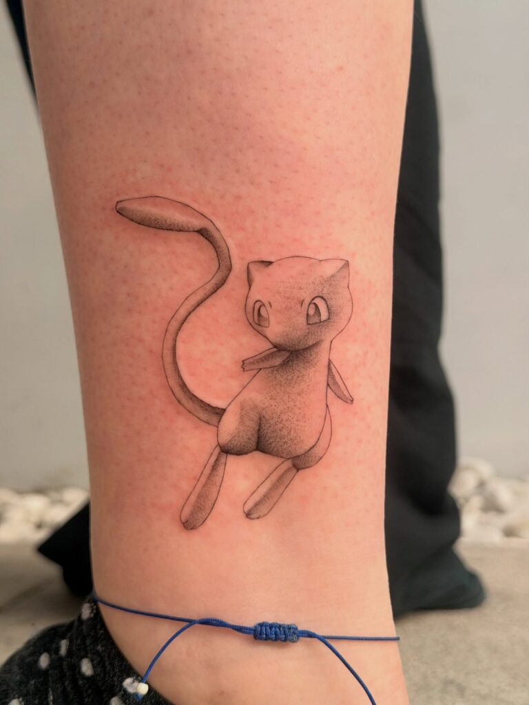 Black-and-grey Mew Pokémon tattoo on the lower leg by Chanelle Pititto