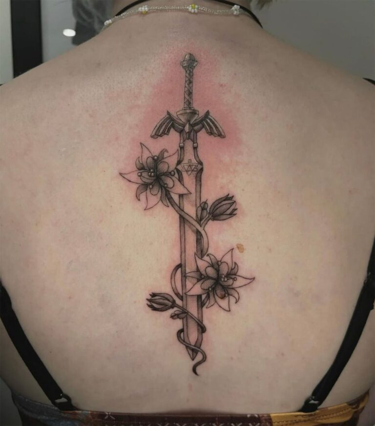 Black and grey tattoo of a dagger wrapped in flowers on the spine