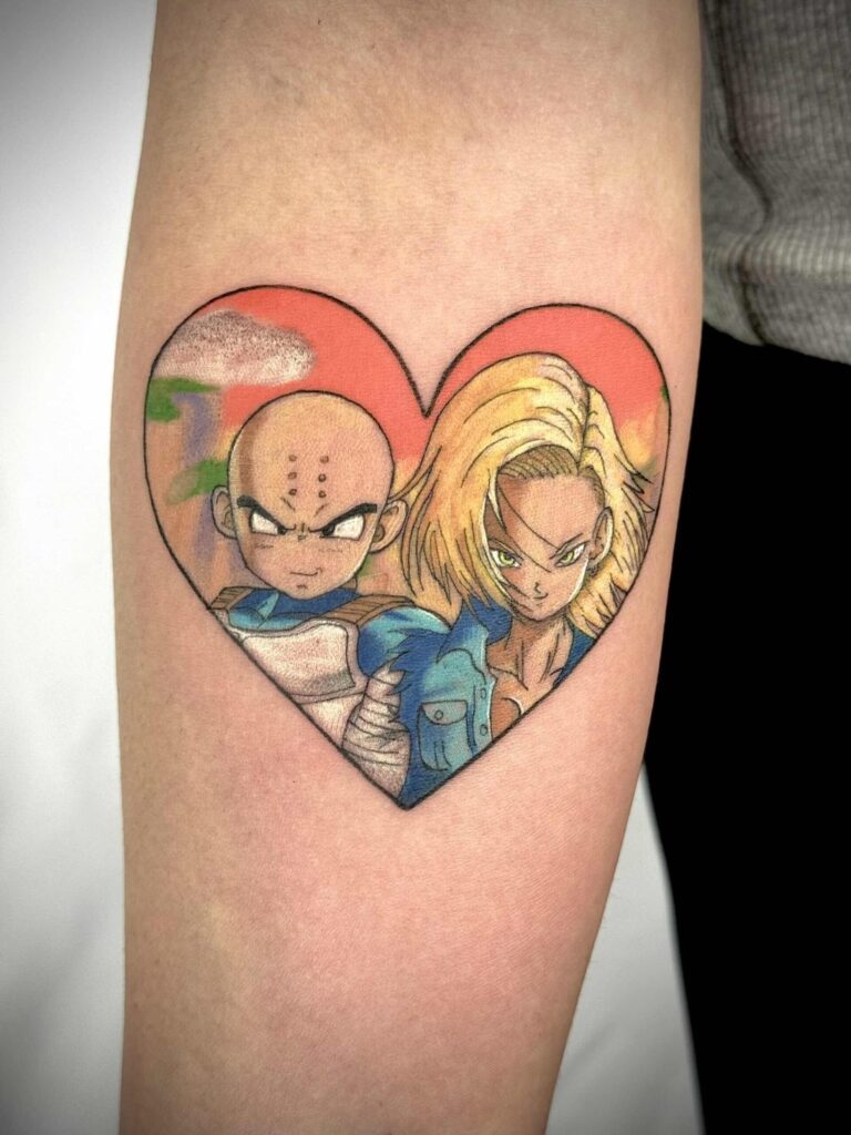 Tattoo of two animated characters in a heart with a surreal landscape.
