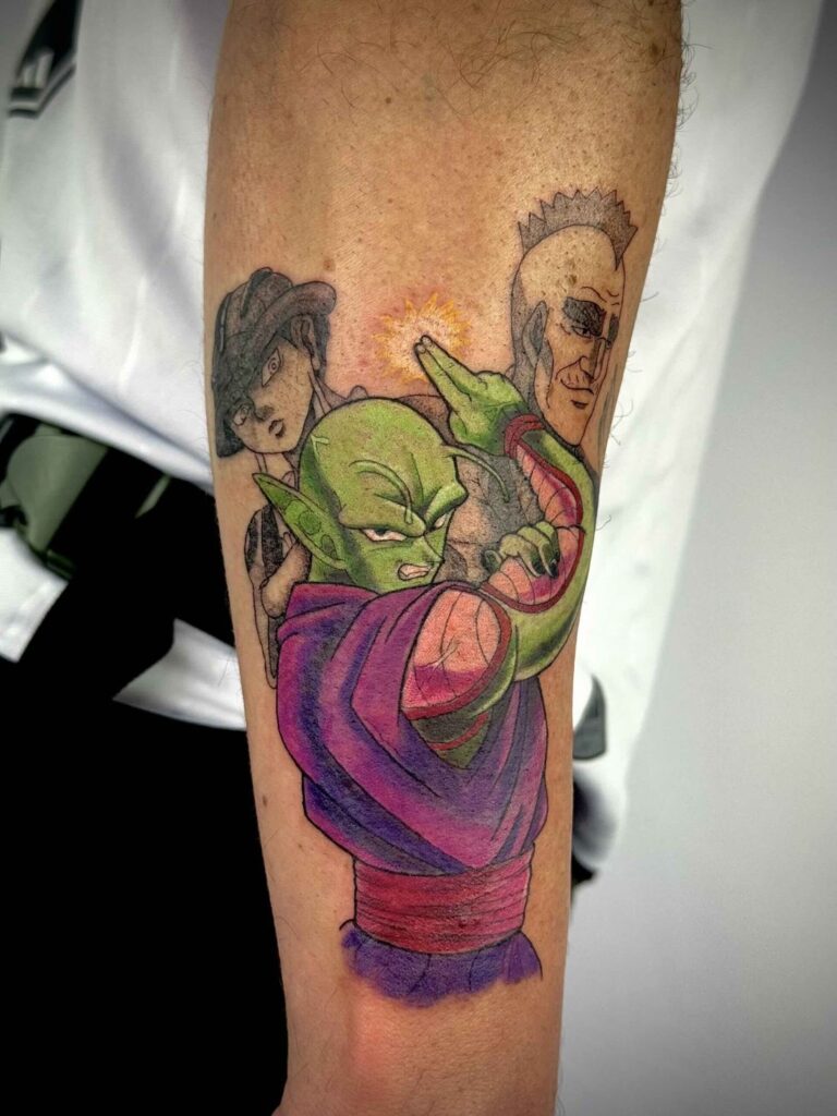Anime-style forearm tattoo with vibrant, colourful characters; green, purple, and red central figure.