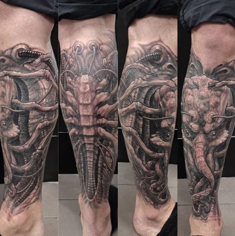 Tattoo of tentacles and alien elements on a leg, monochromatic in black and grey shades.