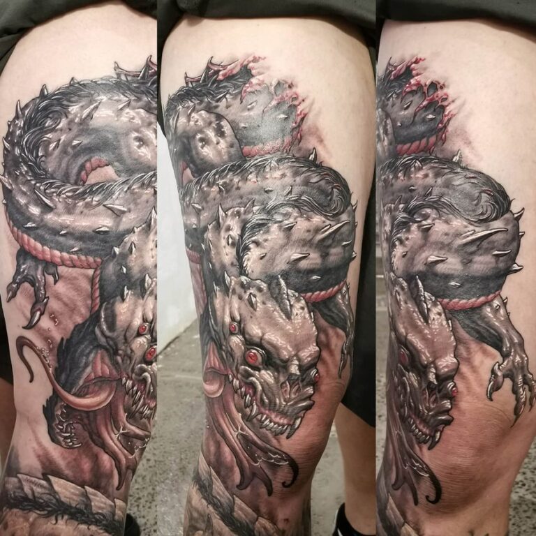 Black and grey realism horror tattoo of a serpent-like monster with red highlights