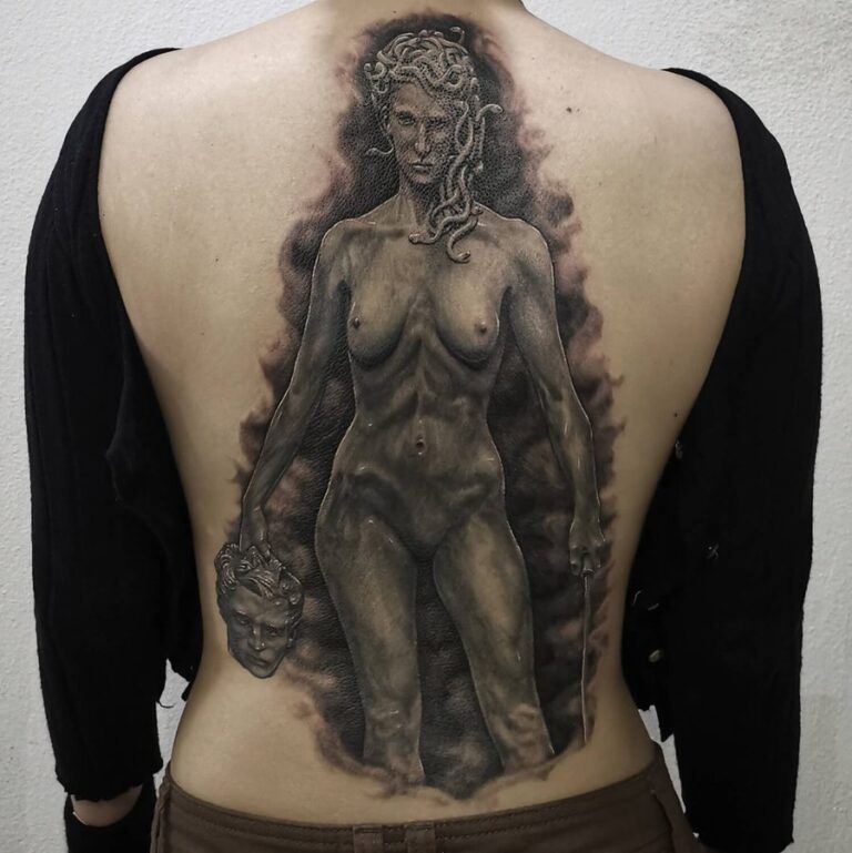 Black and grey realism back piece of Medusa holding a knife and beheaded man's head