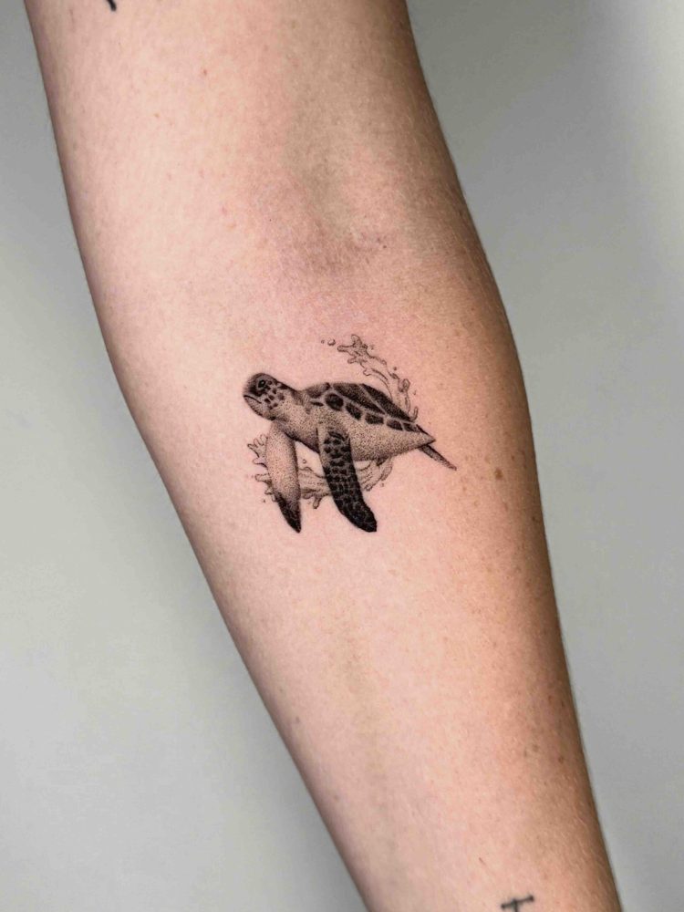 Small sea turtle tattoo with detailed shell and flippers on the forearm by Woody