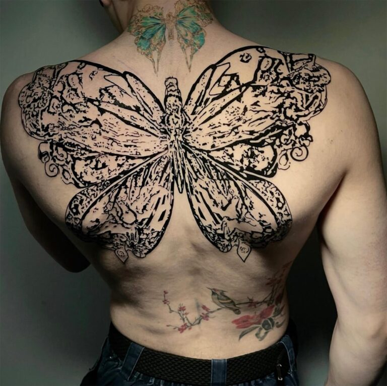 Blackwork butterfly tattoo spanning the top half of the back