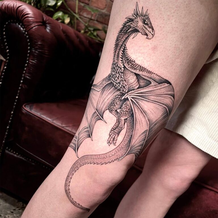 Black and grey dragon tattoo located over the knee