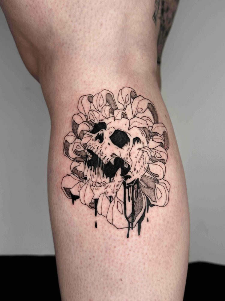 Blackwork skull and petals tattoo with dripping detail