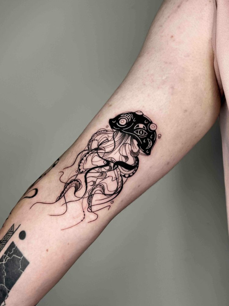 Forearm tattoo of a stylised jellyfish with intricate linework and patterns.