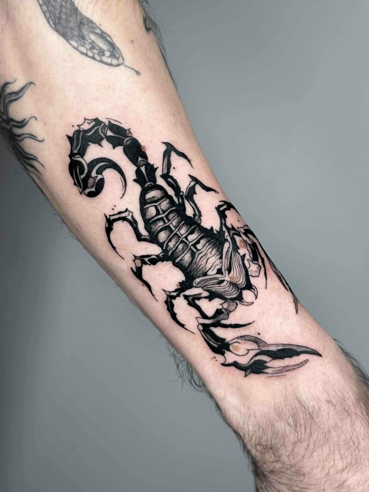 Black and grey scorpion tattoo with intricate shading on arm.